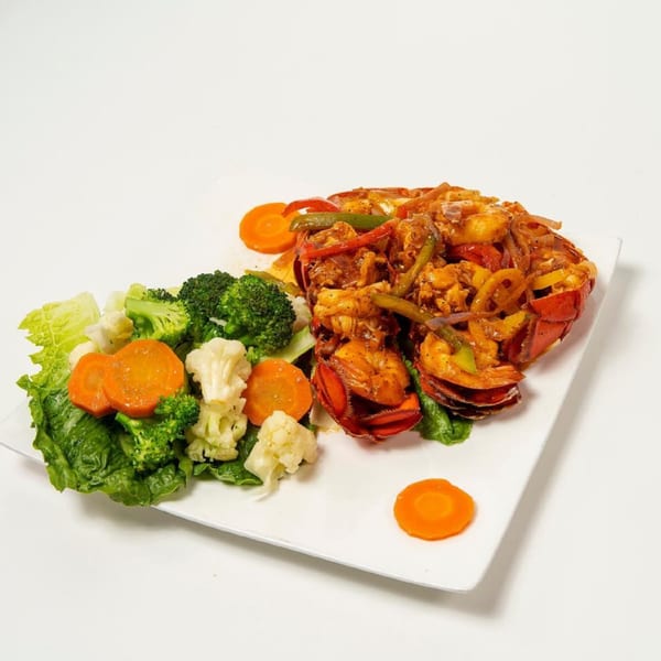 Pollo Lounge and Grill's grilled lobster with mixed vegetables on a white plate.
